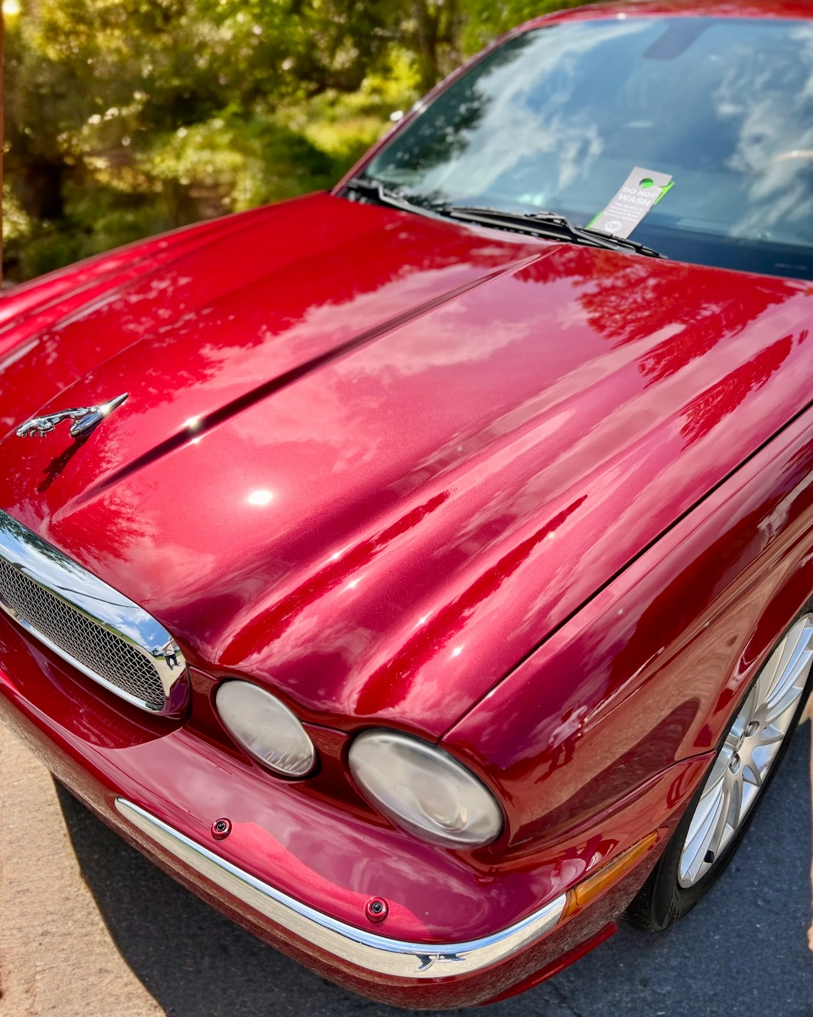 A deep-red luxury car hood with a flawless mirror-gloss ceramic coating finish